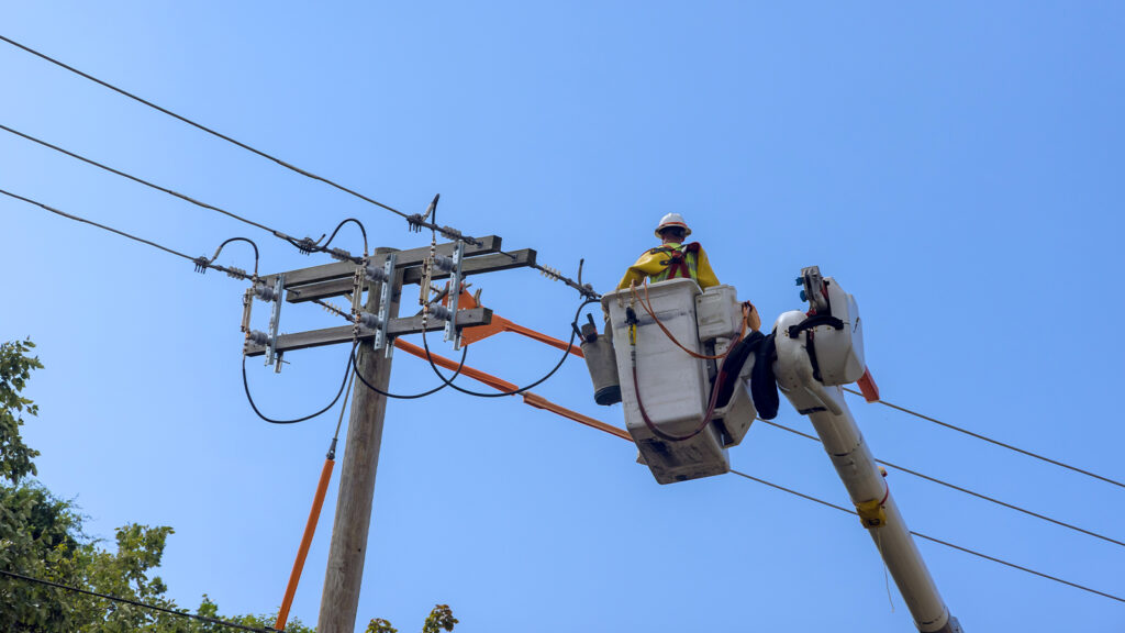 Power electrical lines support servicemen handling damage after hurricane