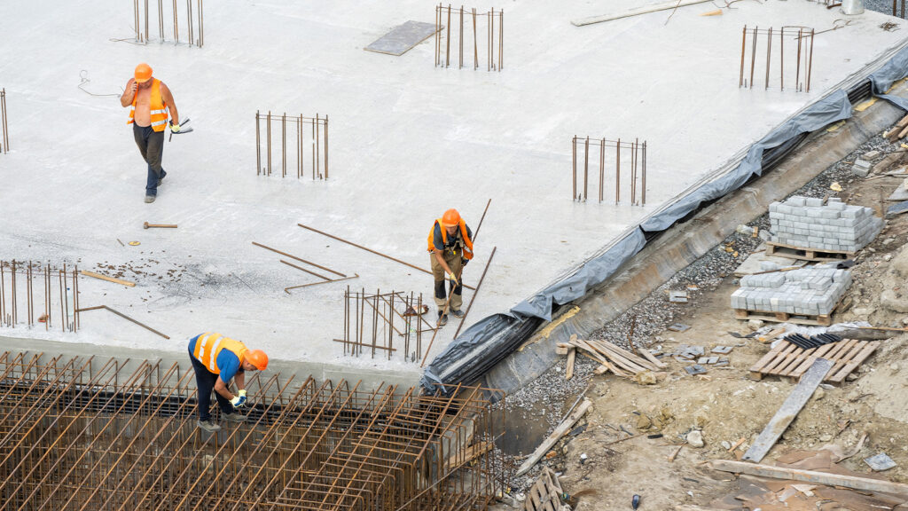 Construction Workers Laying The Building Foundation